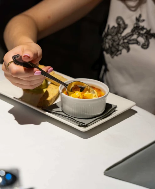 Family enjoying a cosy dinner at a hotel restaurant, sharing dessert on a neatly set table.