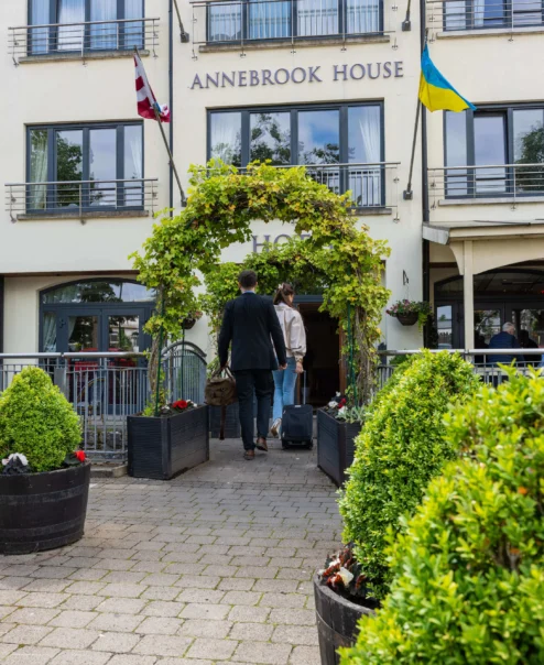 A warm welcome to Annebrook House with a couple entering a charming hotel courtyard.
