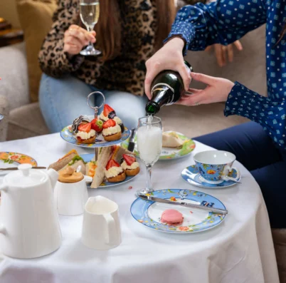 Family enjoying afternoon tea with champagne in a cosy hotel lounge.