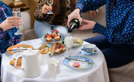 Family enjoying afternoon tea with champagne in a cosy hotel lounge.