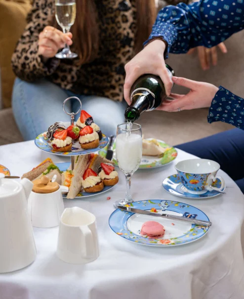 Family enjoying afternoon tea with champagne in a cosy hotel lounge.