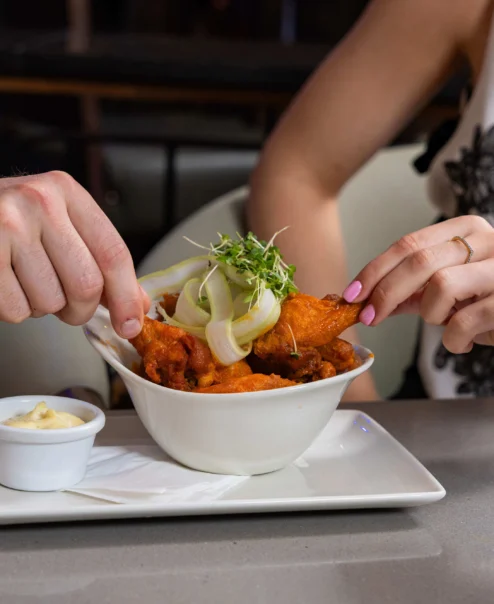 Couple enjoying a meal with a pint and cocktail at a cosy restaurant.