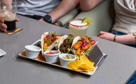 A couple enjoying tacos and drinks in a cosy restaurant setting.