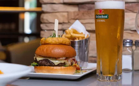 Delicious burger and chips with a cold beer in a cosy restaurant setting.