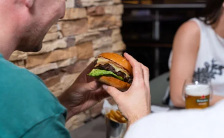 A couple enjoying burgers and drinks at a cosy restaurant.