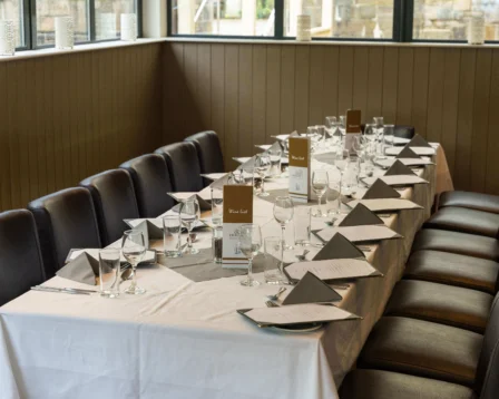 Elegant dining setup in a cosy hotel restaurant with neatly arranged wine menus and tableware.