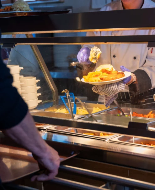 Chef serving a delicious meal at a hotel buffet to a guest.