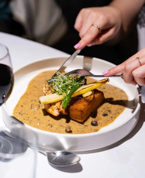 Couple dining, enjoying gourmet meal at a cosy, elegant restaurant with elegant ambience.