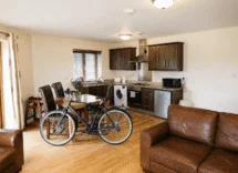 Inviting lounge with leather sofas and bike; modern kitchen for relaxed family stay.