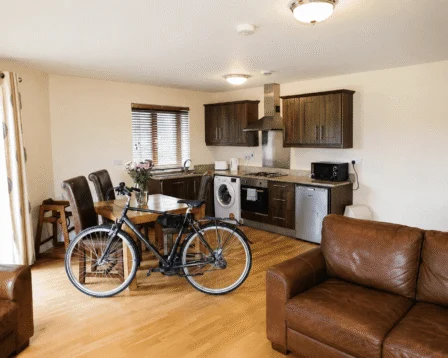 Inviting lounge with leather sofas and bike; modern kitchen for relaxed family stay.