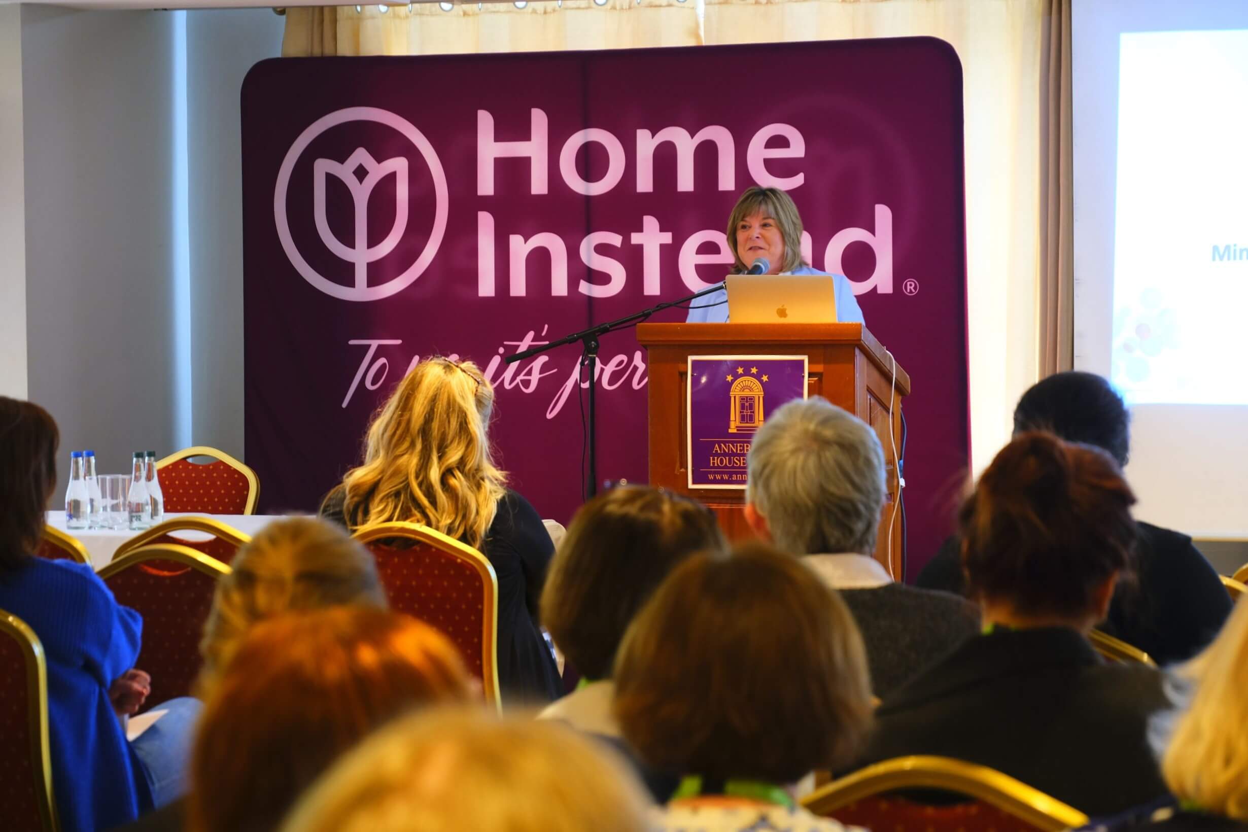 Speaker addressing a warm audience at a hospitality conference.