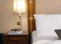 Cosy hotel room with inviting bed and bedside lamp