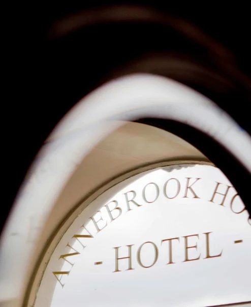 Elegant hotel entrance with arched design, welcoming guests to a serene stay.