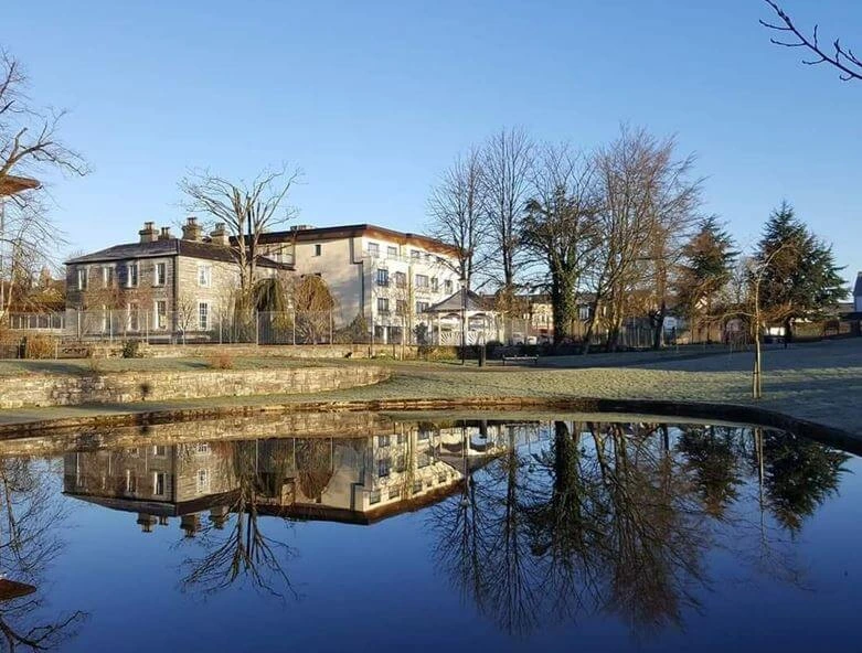 Families enjoying a tranquil resort garden beside a reflecting pond.