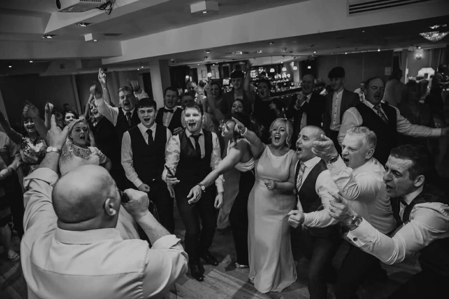 Guests joyfully singing together at a lively hotel event.