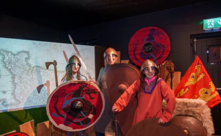Families enjoying historical role-play at a themed hotel with medieval armour displays.