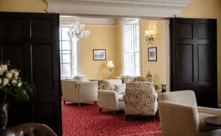 A warm hotel lounge with cosy seating and sunlit windows, inviting family to relax.