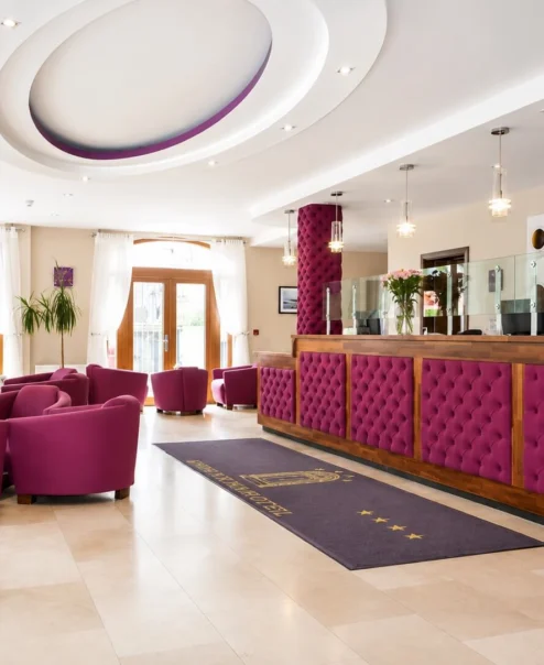 Group relaxing in hotel lobby with vibrant seating, near reception desk.