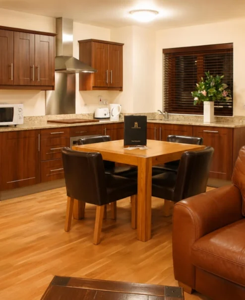 Cosy and inviting hotel suite with a warm wooden kitchen and comfortable seating area.