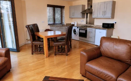 Cosy hotel suite with kitchen and seating area.