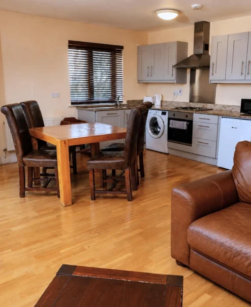 Cosy hotel suite with kitchen and seating area.