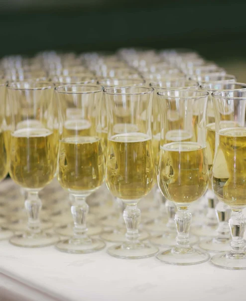 Rows of champagne glasses on a table, prepared for a festive hotel event.