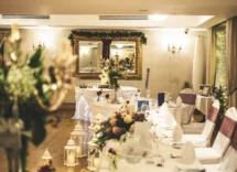 Elegant hotel banquet hall with floral decor and table settings for family gathering.