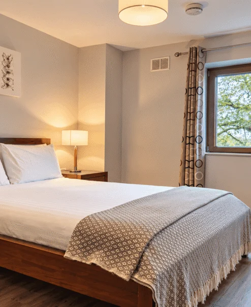 Cosy hotel room with a double bed, art, and tree view.