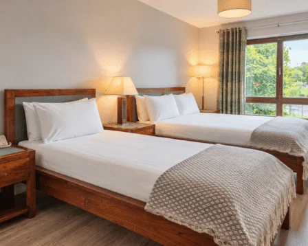 Cosy twin room with warm lighting and garden view at a resort.