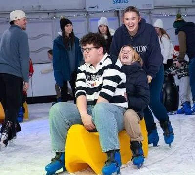 Family joyfully ice-skating at a winter resort rink.